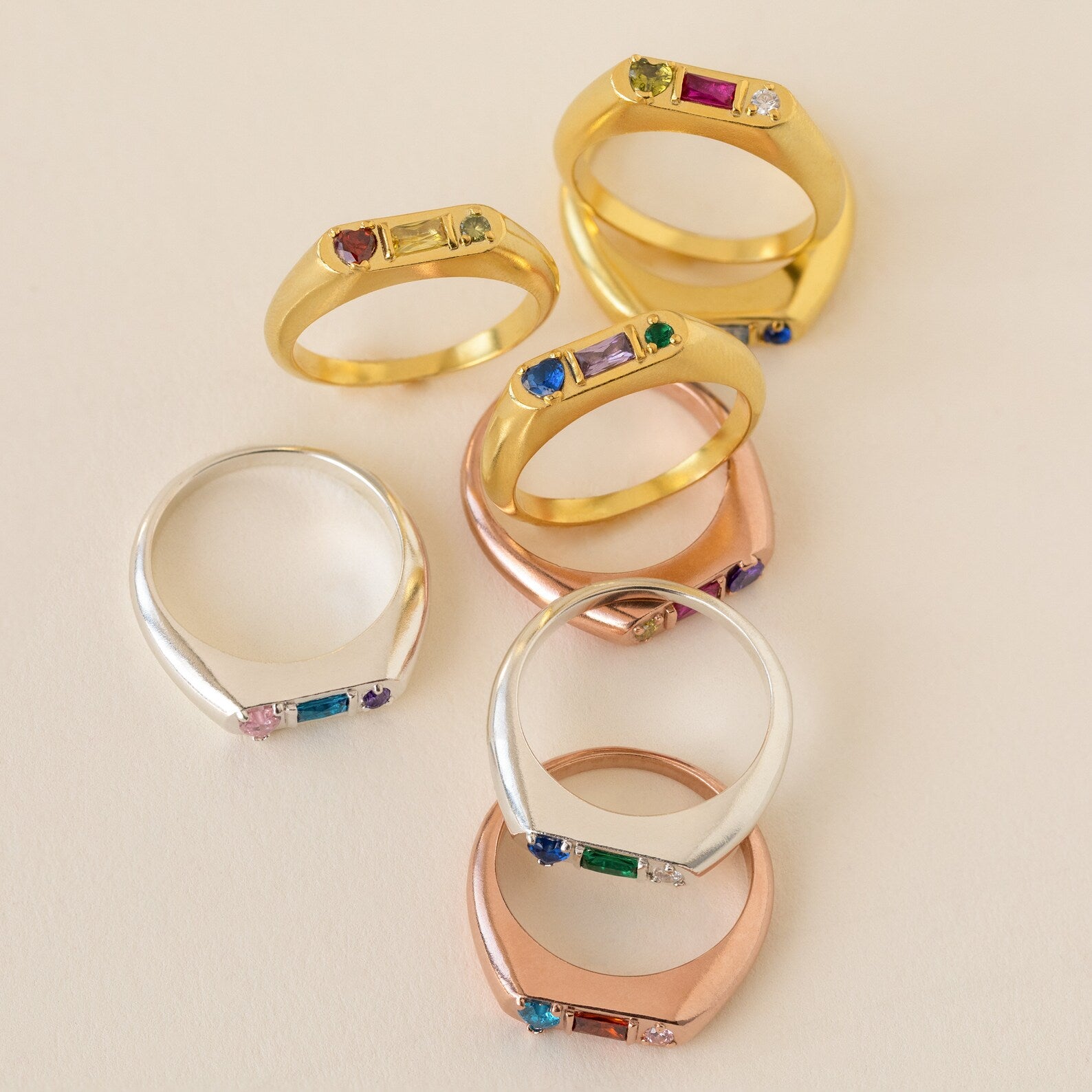 The Bold Birthstone Signet Ring in Rose Gold features a customizable gemstone, highlighting the beauty of personalized jewelry on a light background.