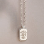 The Ribbed Flower Tag Necklace features a rectangular, flower-engraved pendant and vintage-inspired style—ideal for adding everyday charm.