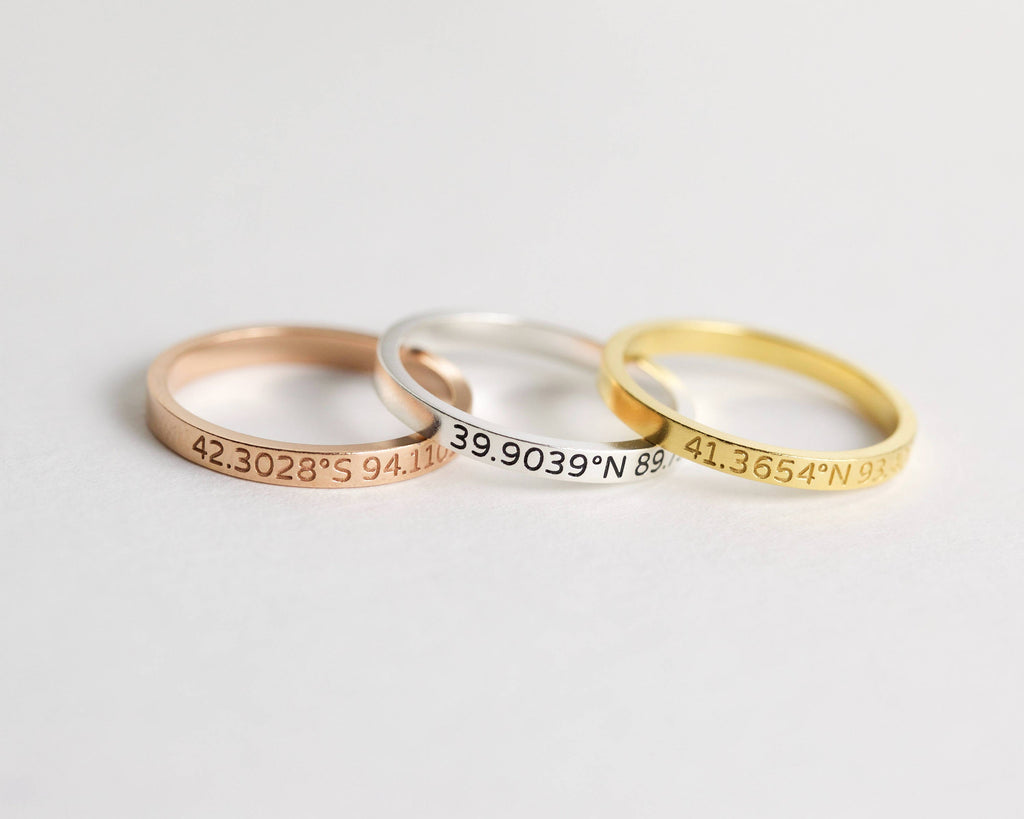 The Coordinates Band features three metal stacking rings—rose gold, silver, and gold—engraved with geographic coordinates to capture a meaningful memory.