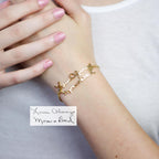 A Handwriting Bracelet in gold, featuring "Love Always Mom & Dad" in cursive, worn with light pink nails—ideal for daily wear or as a meaningful piece of memorial jewelry.