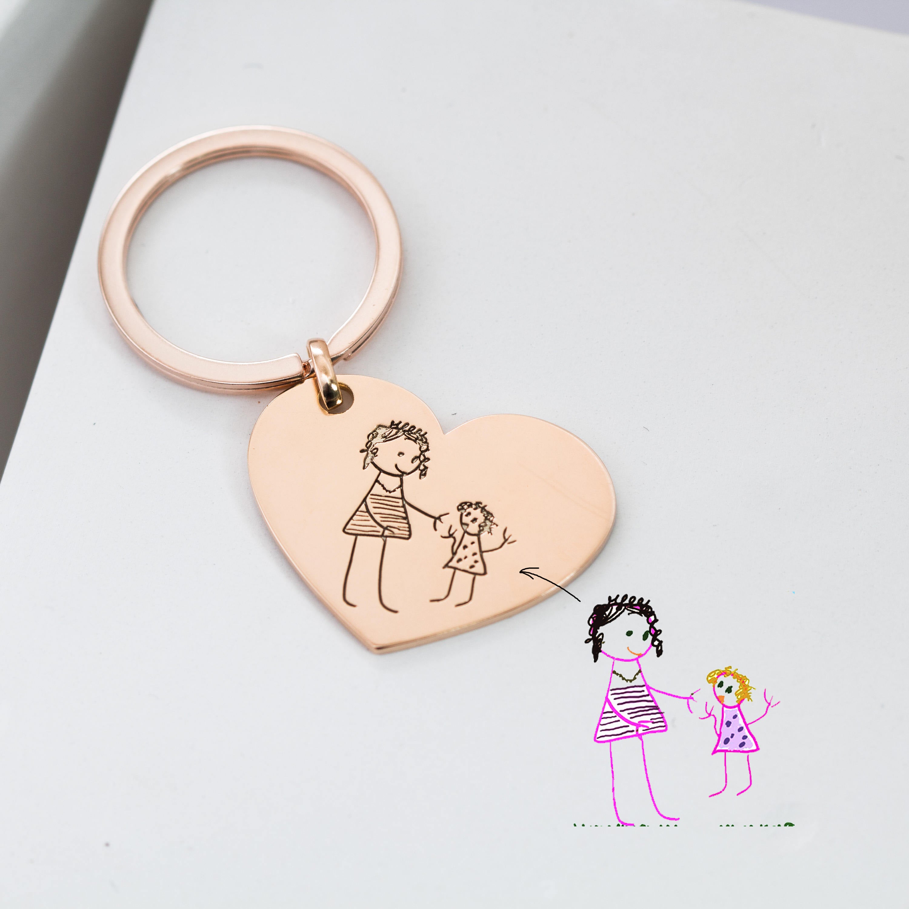 The Handwriting Heart Keychain is personalized with a child’s drawing of an adult and child holding hands, engraved to match your artwork for a unique keepsake that captures your special memories.