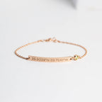 The Thin Coordinates Bar Bracelet in rose gold features custom location engraving and a small yellow gemstone, shown on a white background.
