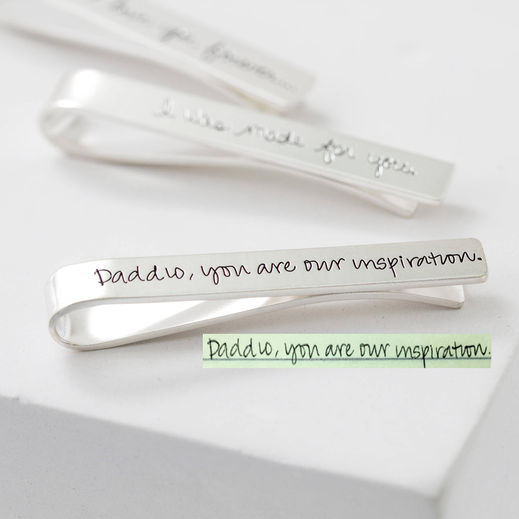 A silver Handwriting Tie Clip engraved with "Daddio, you are our inspiration."—a memorable personalized gift.