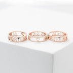 The Roman Numerals Ring in Rose Gold—featuring elegant cutout numbers and a heart design—is displayed on a white surface, making it a perfect choice for commemorating a personal milestone.