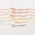 The Minimal Name Necklace features delicate chains with names—Caroline, Andrew, Ashley, Madelyn, Ryan, and Emily in script—perfect for lovers of personalized dainty jewelry.