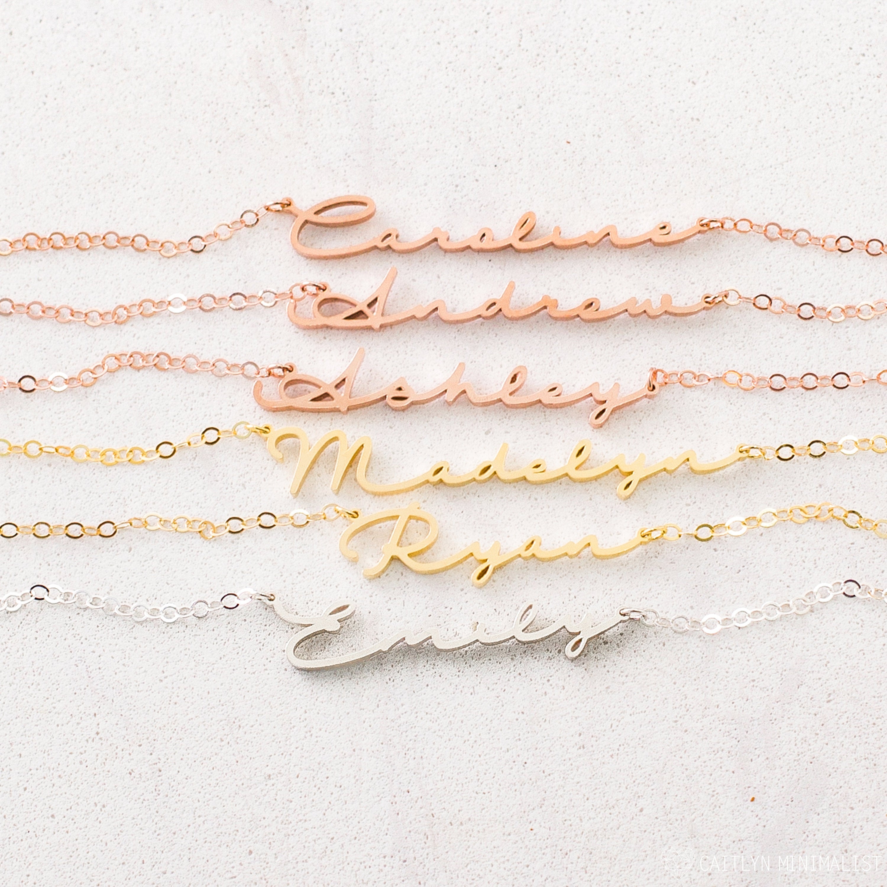 The Minimal Name Necklace features delicate chains with names—Caroline, Andrew, Ashley, Madelyn, Ryan, and Emily in script—perfect for lovers of personalized dainty jewelry.