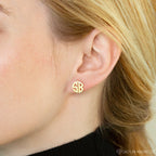Close-up of a woman's ear wearing gold Block Monogram Earrings, featuring the letters SB—ideal for adding a geometric touch to your earring stack.