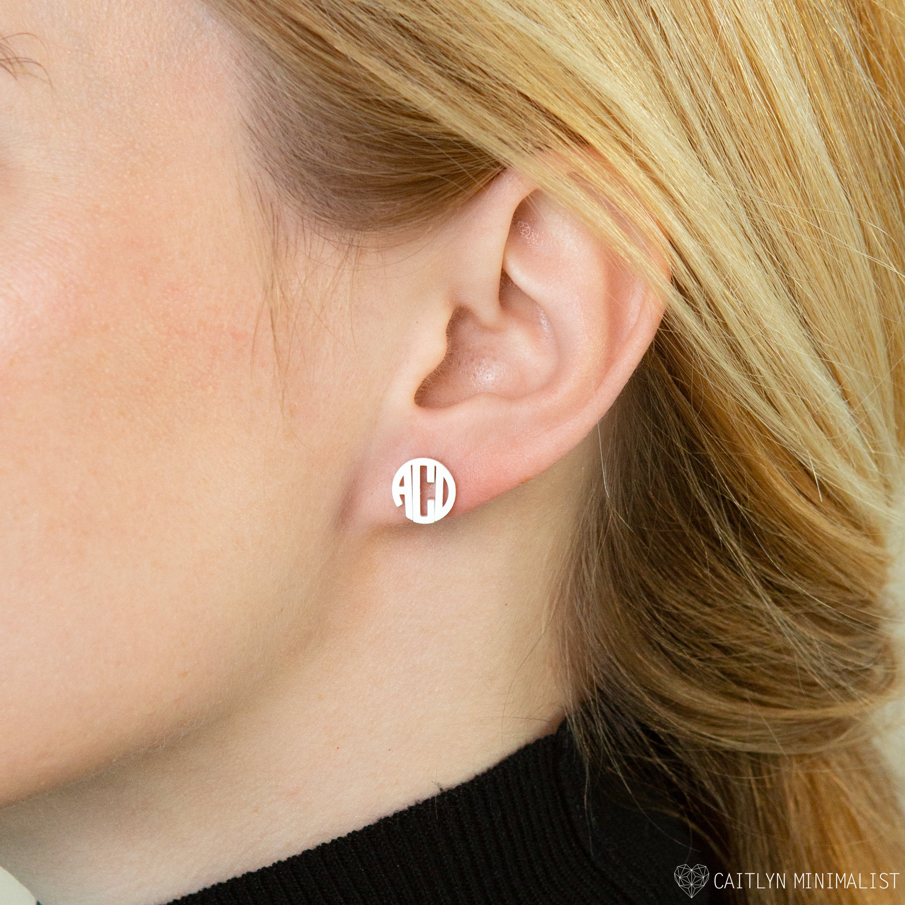 Close-up of a woman wearing Block Monogram Earrings, featuring a white geometric design—ideal for adding style to your earring stack.
