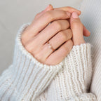 Close-up of hands in a cream knit sweater, wearing the Alex Dainty Letter Ring in Rose Gold—a perfect piece of personalized jewelry.