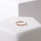 The Arthur Skinny Name Ring, a thin personalized ring engraved with Coco and a small heart, is displayed on a white surface.