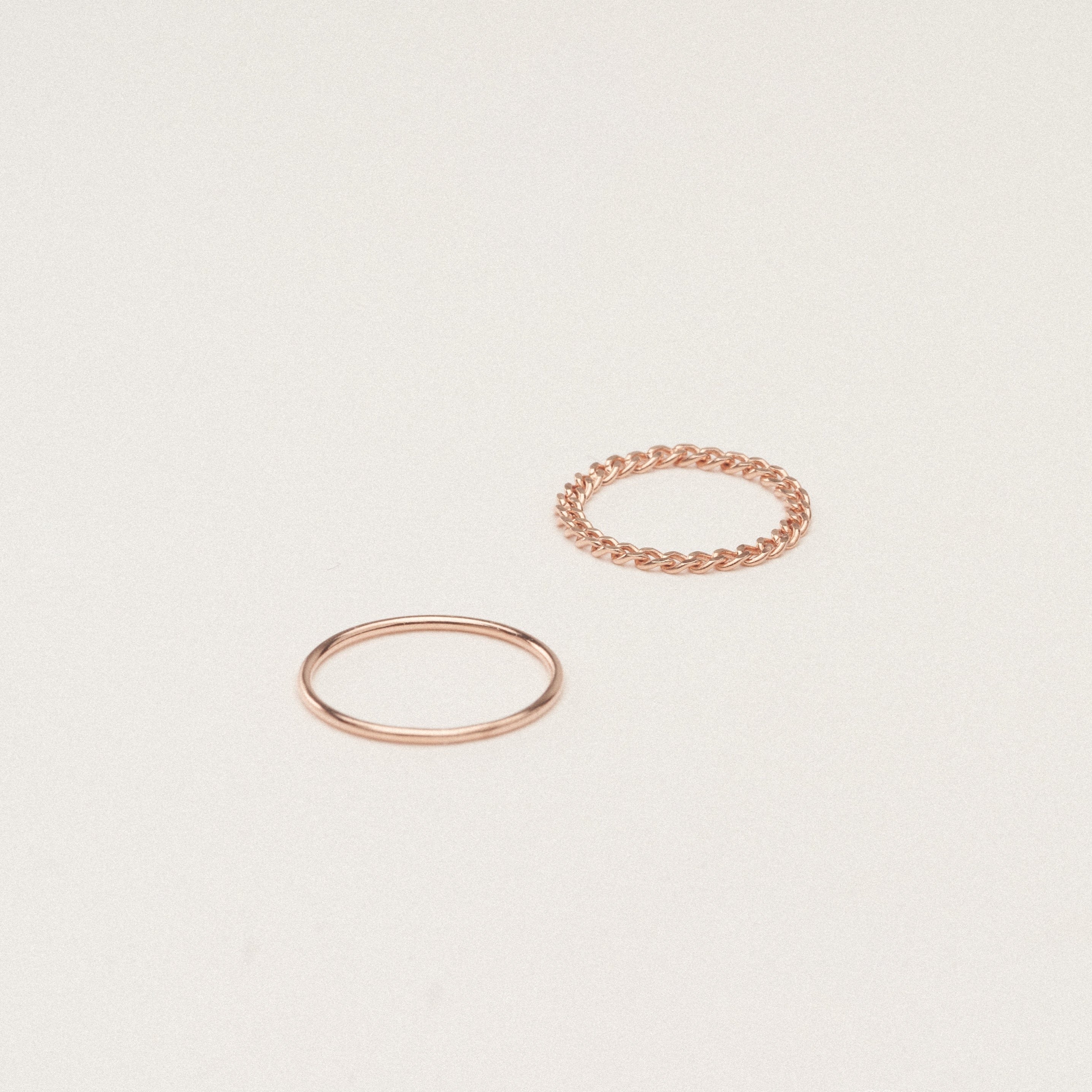 The Bold Stacking Ring Set features two modern, minimal gold rings—one with a smooth band and one with a twisted rope design—displayed on a simple light background.