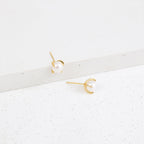 Zoe Pearl Studs shown on a white, textured surface blend contemporary style with timeless elegance, making them the perfect pearl earrings for any occasion.