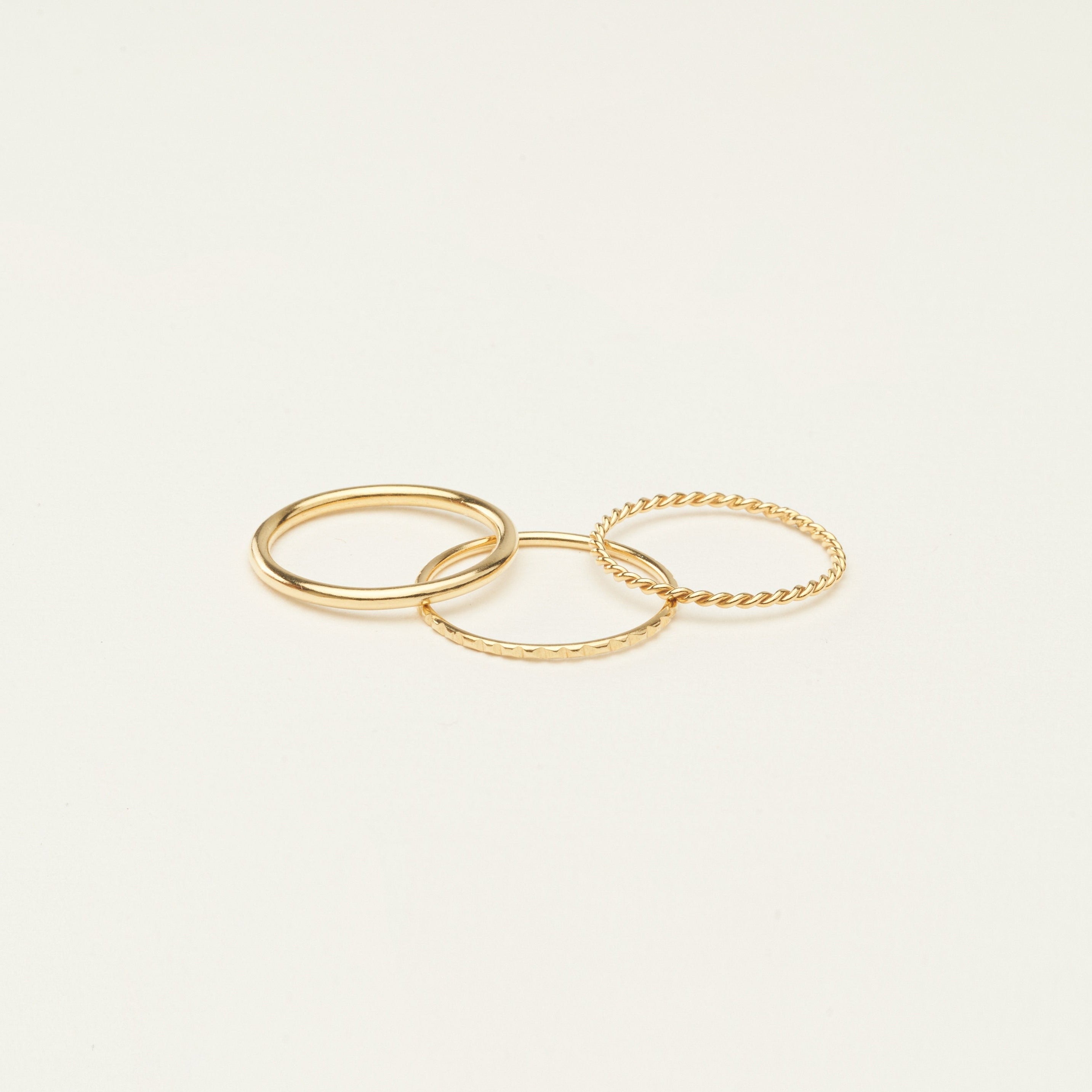 Three sterling silver thin stacking rings with different textures are arranged on a plain, light background—ideal for creating a stylish ring stack or giving as a thoughtful Christmas gift.