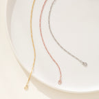 Three delicate unisex Figaro Bracelets in gold, rose gold, and silver—each reflecting modern jewelry style—are elegantly displayed on a white plate.