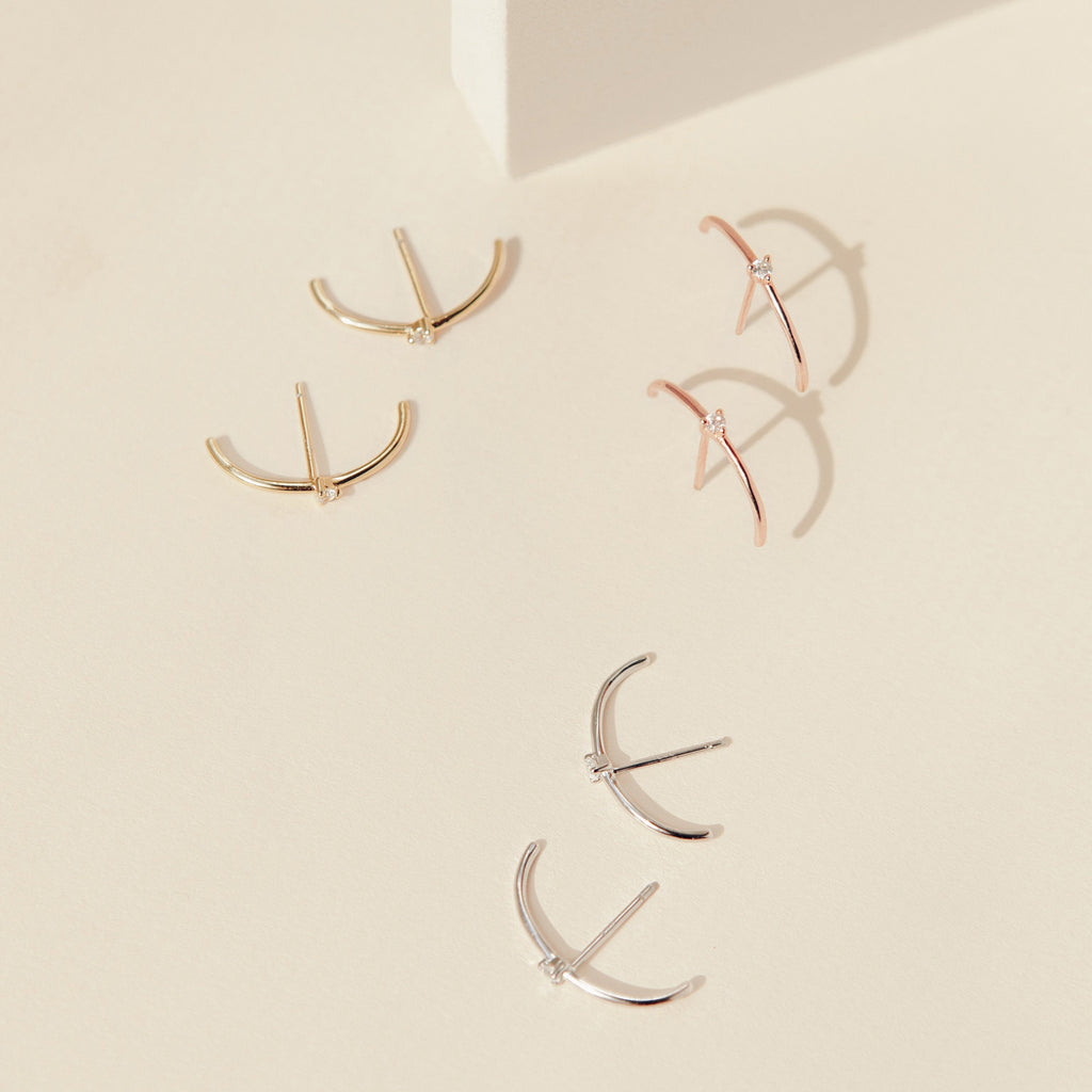 Arc Studs: A set of three pairs of minimalist arc-shaped earrings in gold, rose gold, and silver—ideal for fans of simple ear jewelry.