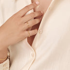 Close-up of model’s hand adjusting clothing, with the link ring visible to showcase its wearability and subtle shine.