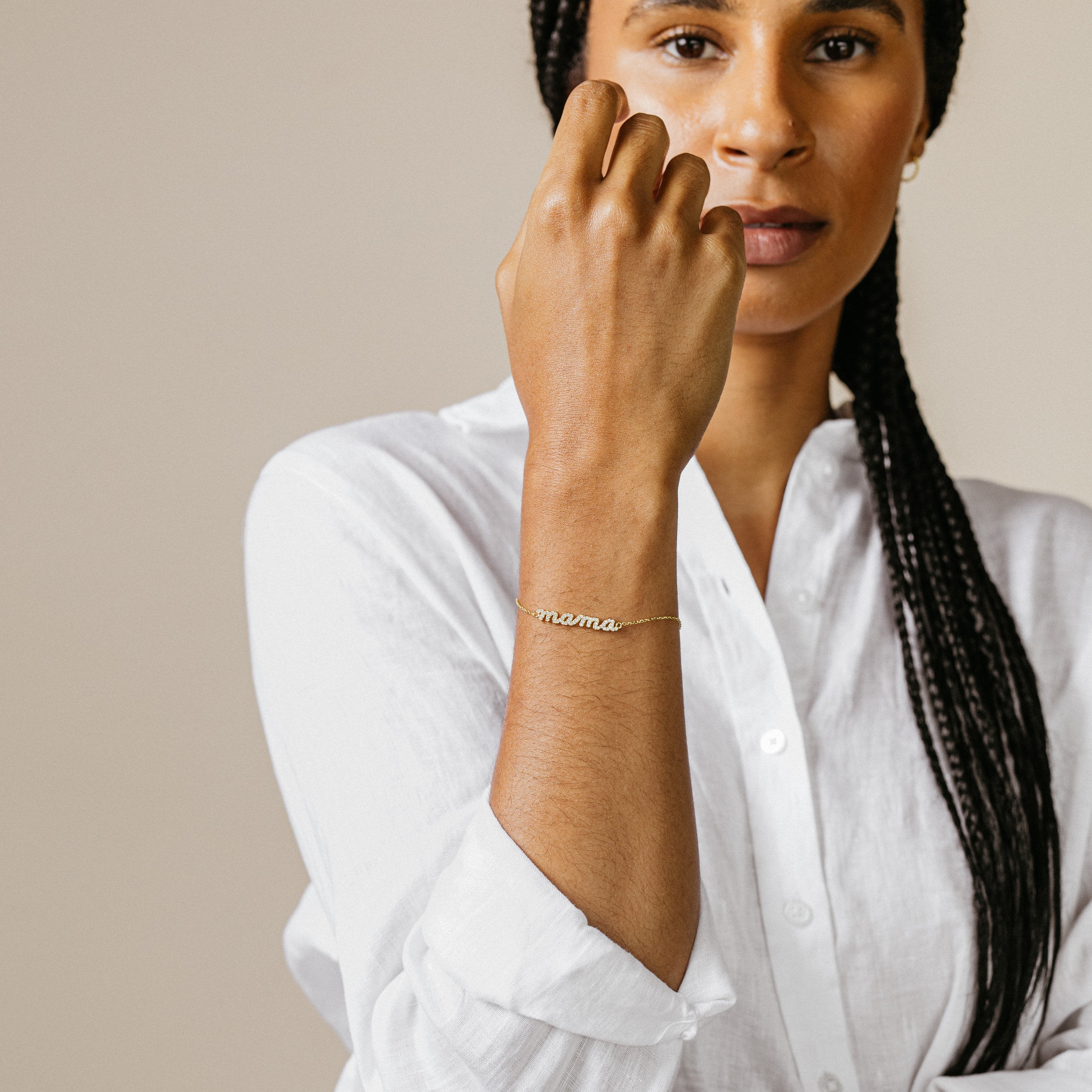 Woman in a white shirt wears the Pave Mama Script Bracelet on her wrist, celebrating the elegance of mama jewelry.