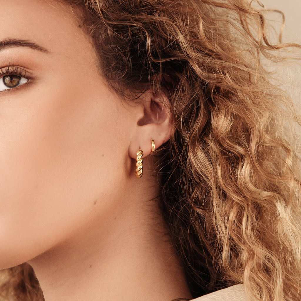 Close-up of a woman with curly hair wearing Remi Twist Hoops, ideal for minimal jewelry lovers.