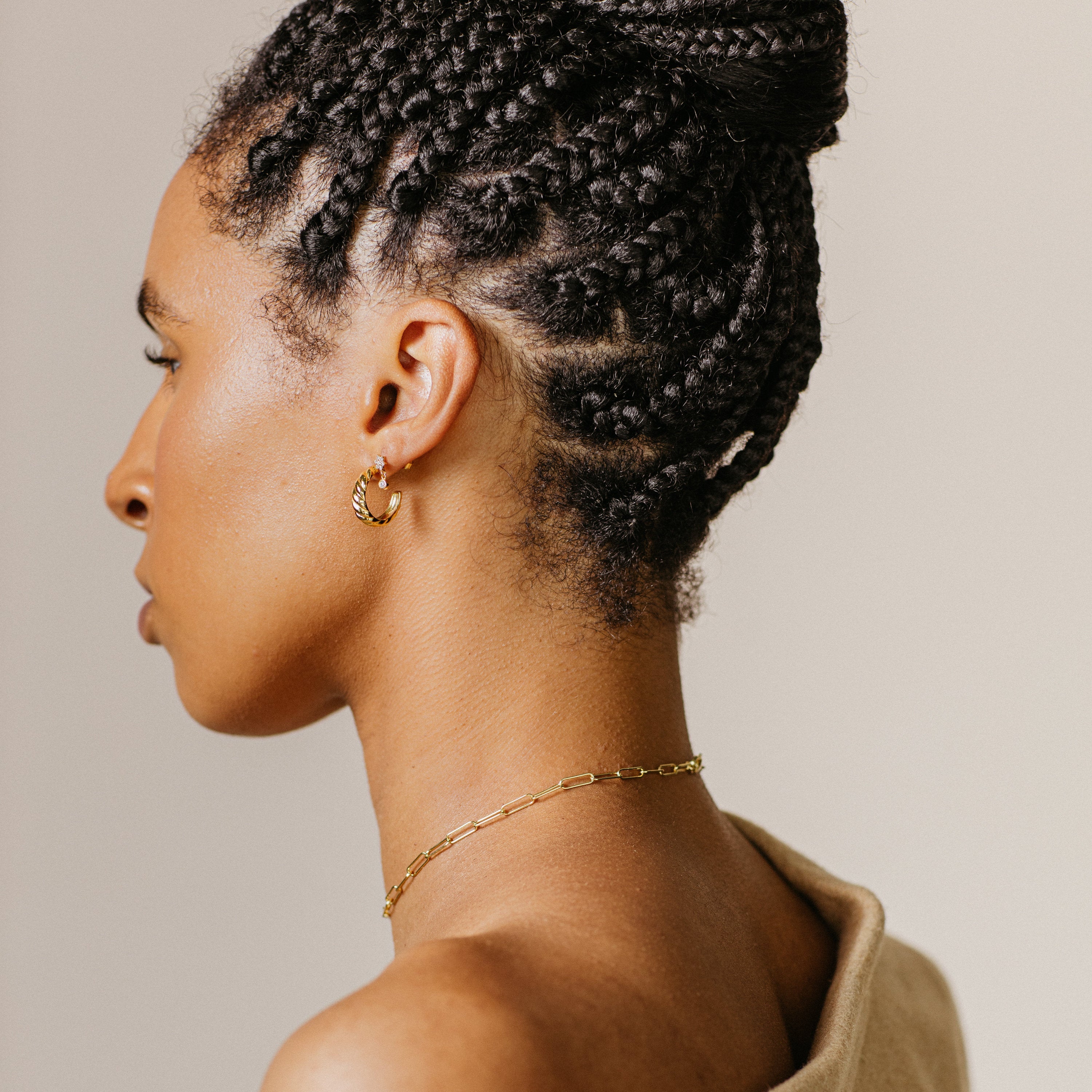 Woman with braided hair, facing away from the camera, wearing Croissant Hoops and a chain necklace.