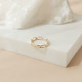 A single link ring displayed on a soft, neutral-toned surface—showcasing its minimalistic 3 mm band and polished finish.