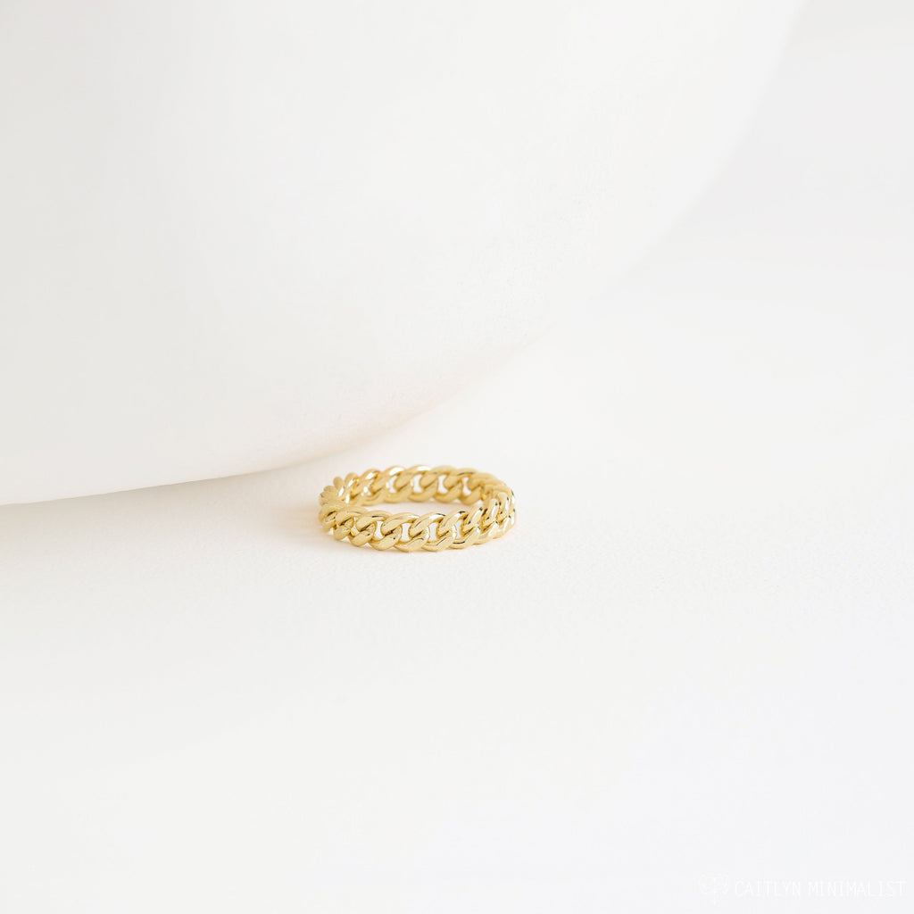 The Curb Chain Ring sits on a white surface with a minimalist backdrop, exuding subtle goth glam vibes.
