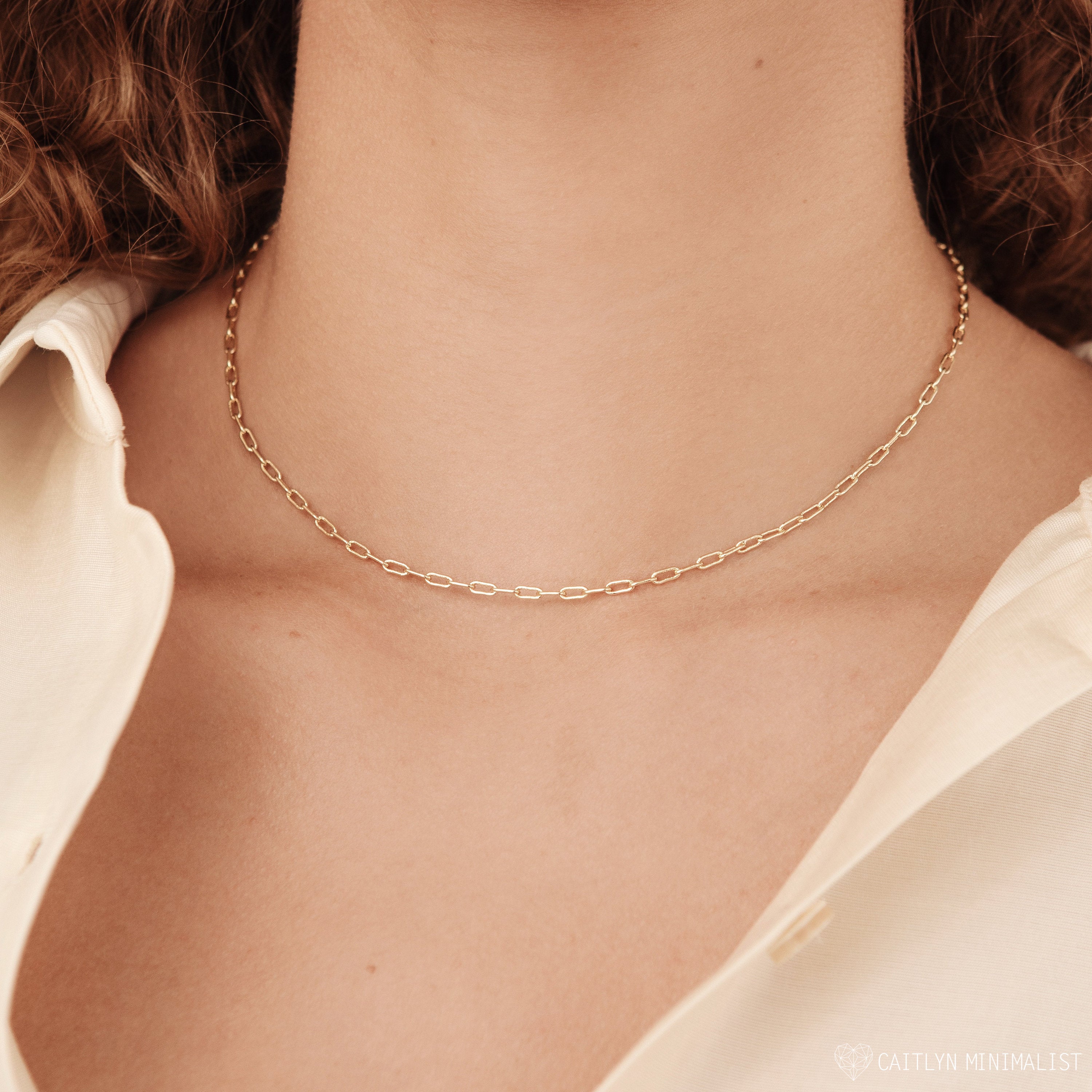 A woman wears the Dainty Link Chain Necklace with an ivory shirt, shown in a close-up at the neck.