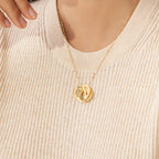 The Interlocking Family Necklace features engraved rings, shown on a woman in a light beige ribbed sweater—ideal as a custom-engraved necklace or meaningful family pendant.