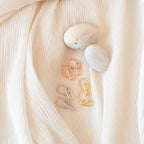 The Amanda Link Earrings in 18K Gold, with a minimalist design, are displayed on cream-colored textured fabric.