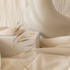 Minimalist scene featuring cream fabric, a sculpted figure, dried grass, a seashell, and the Classic Heart Studs on a box—an elegant backdrop to highlight these cute earrings.