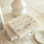 The Pave Mama Letter Necklace, available in gold, silver, and rose gold, shines on a white marble stand with soft lighting—perfect as a motherhood accessory and a thoughtful gift for mom.