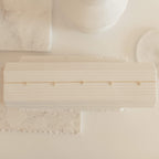 The Diamond Station Necklace features delicate gold with sparkling gems, displayed on a textured white surface in soft lighting—modern elegance for a timeless accessory.