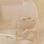 A pair of Petite Tiny Name Rings displayed on a clear box.