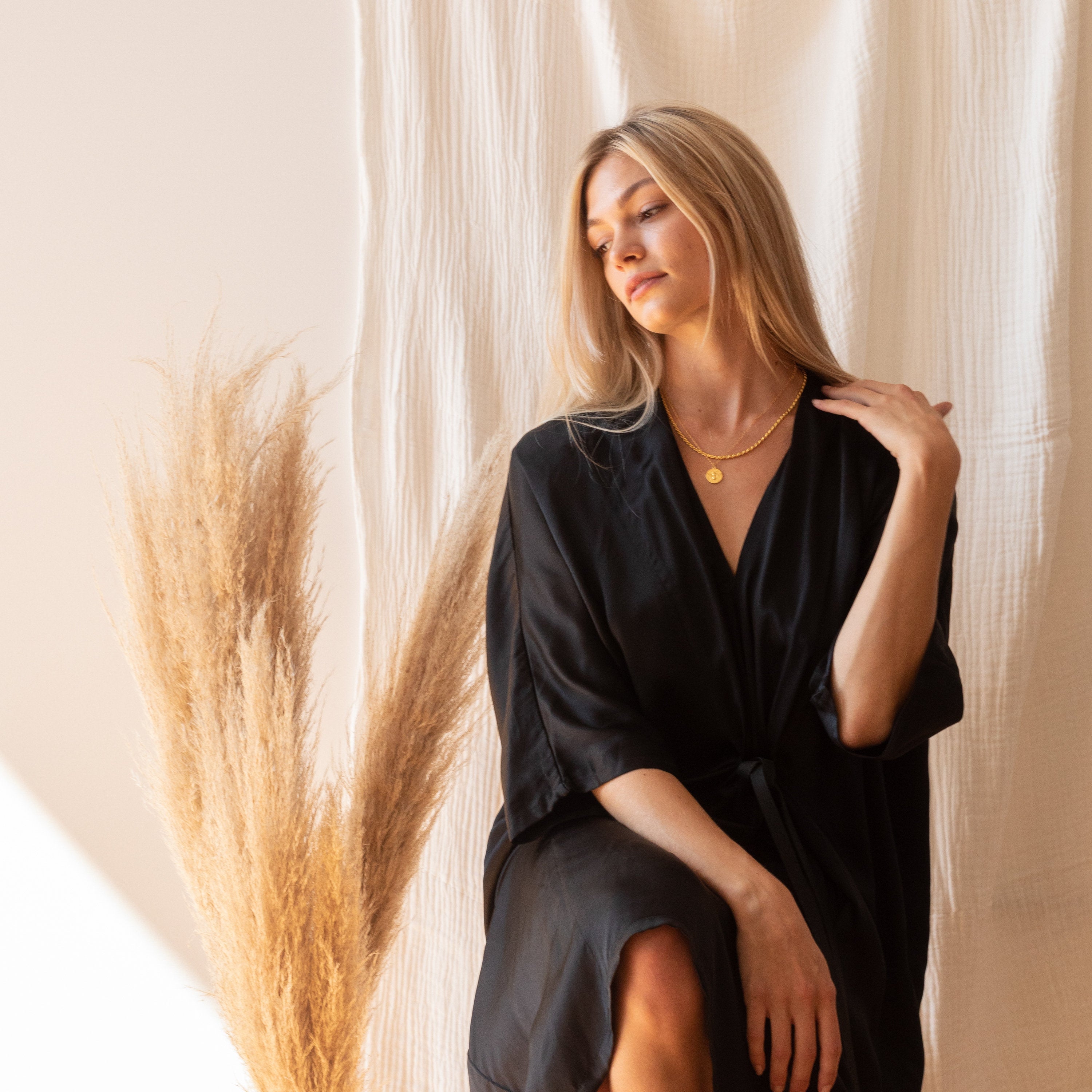 Model wearing two layered gold necklaces, including the rope chain, styled with a coin pendant.