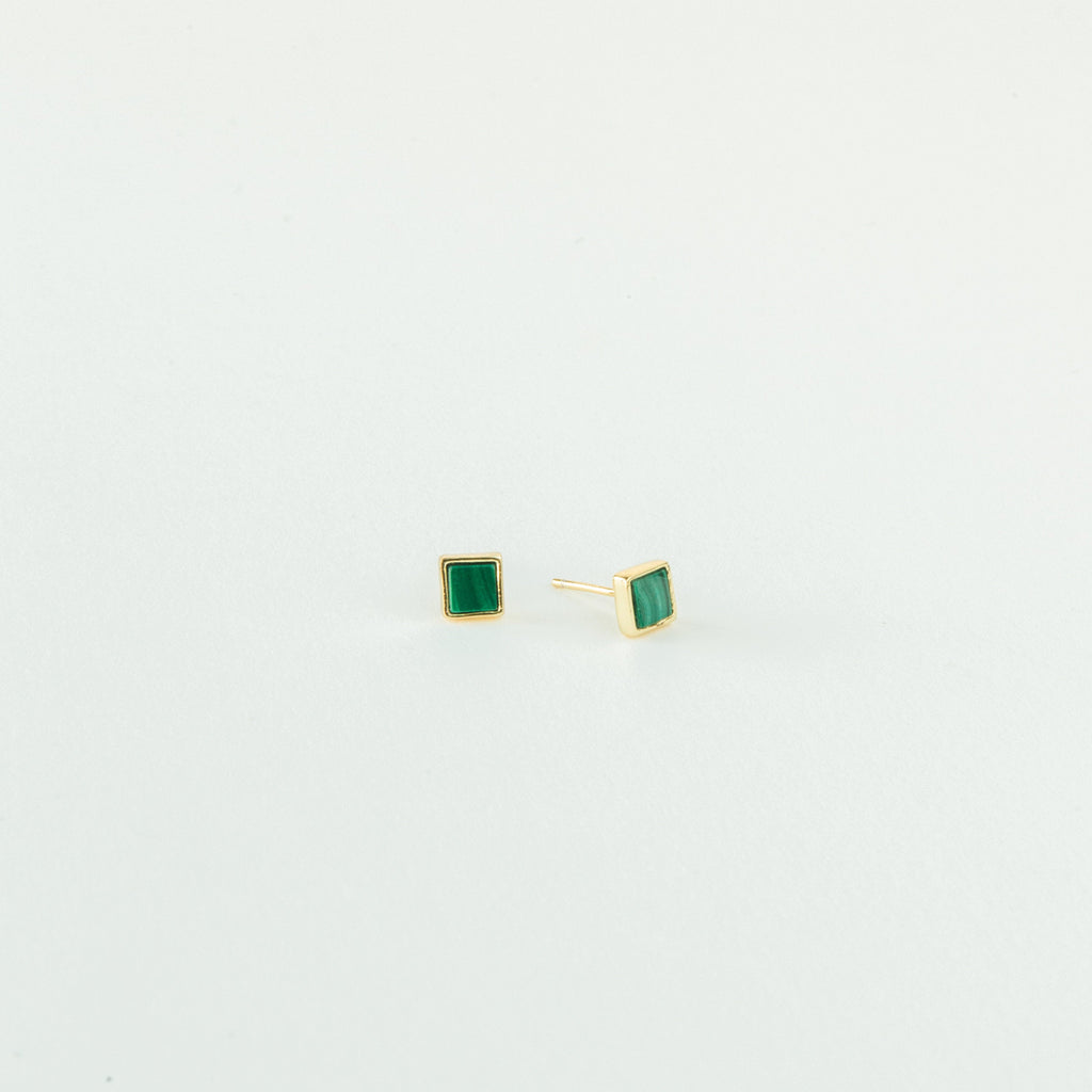Malachite Studs: gold stud earrings with small green square gemstones in a geometric box shape, shown on a plain white background.