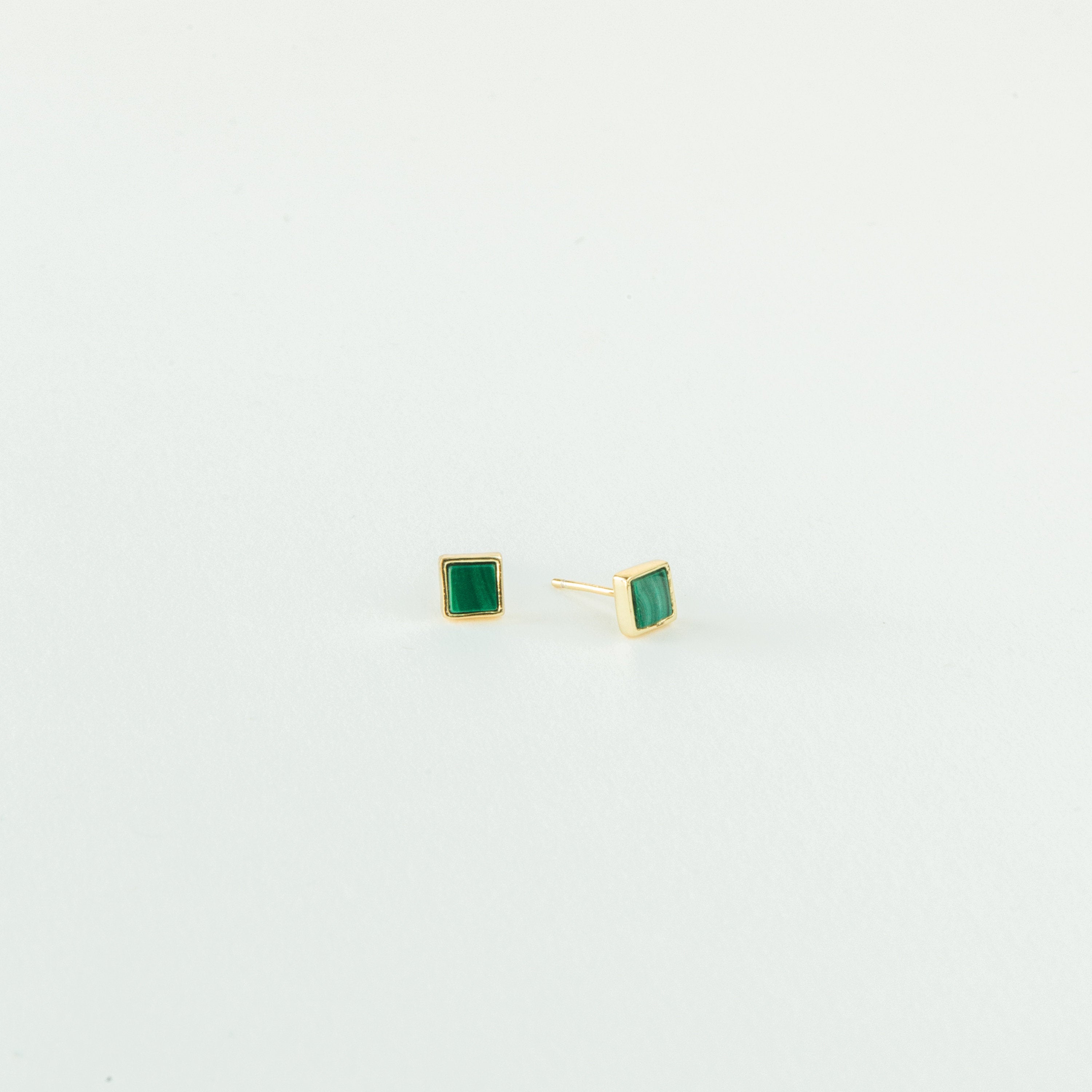 Malachite Studs: gold stud earrings with small green square gemstones in a geometric box shape, shown on a plain white background.