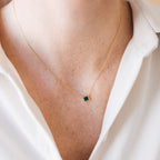 The Malachite Necklace, featuring a small green pendant, adds elegance over a white collared shirt—perfect for gemstone jewelry lovers.