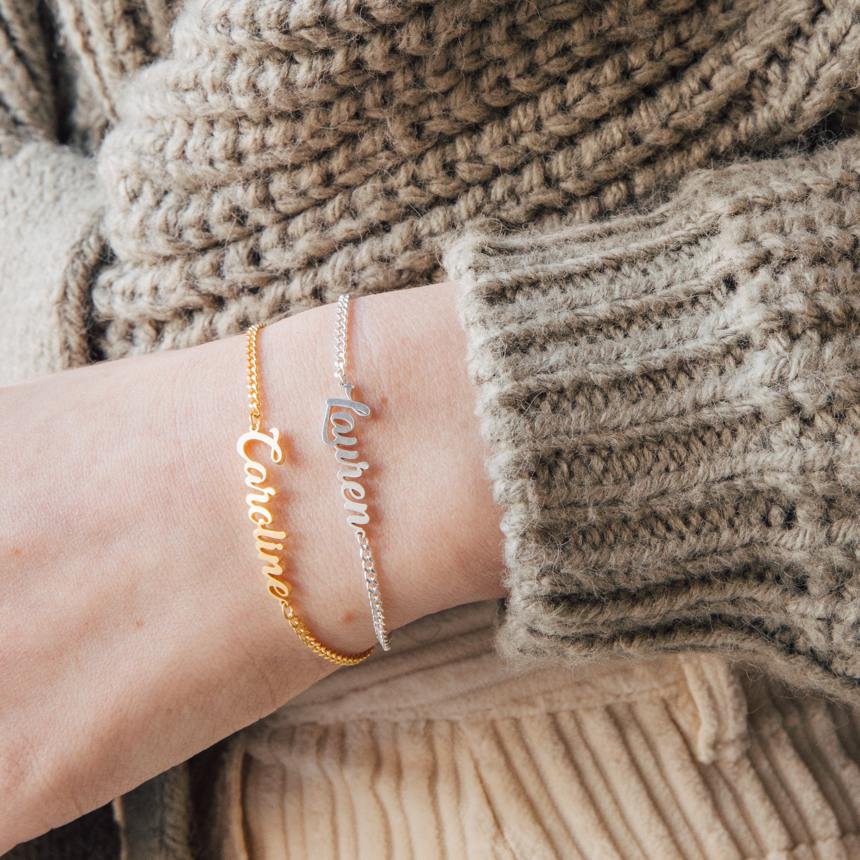Wearing gold and silver Ladybirds Name Curb Bracelets personalized with "Caroline" and "Lauren" alongside a chunky knit sweater creates a modern, stylish look.