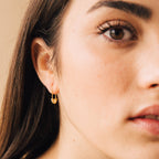 Close-up of a woman’s face wearing funky Ava Earrings, focusing on her eye, eyebrow, and lips.