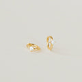 A pair of Athena Huggies crafted in gold and delicately accented with a sparkling diamond.