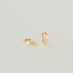 A pair of Athena Huggies crafted in gold and delicately accented with a sparkling diamond.