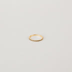 The Amber Eternity Ring is a delicate gold, stackable ring featuring small beads along its band, shown on a plain white background.