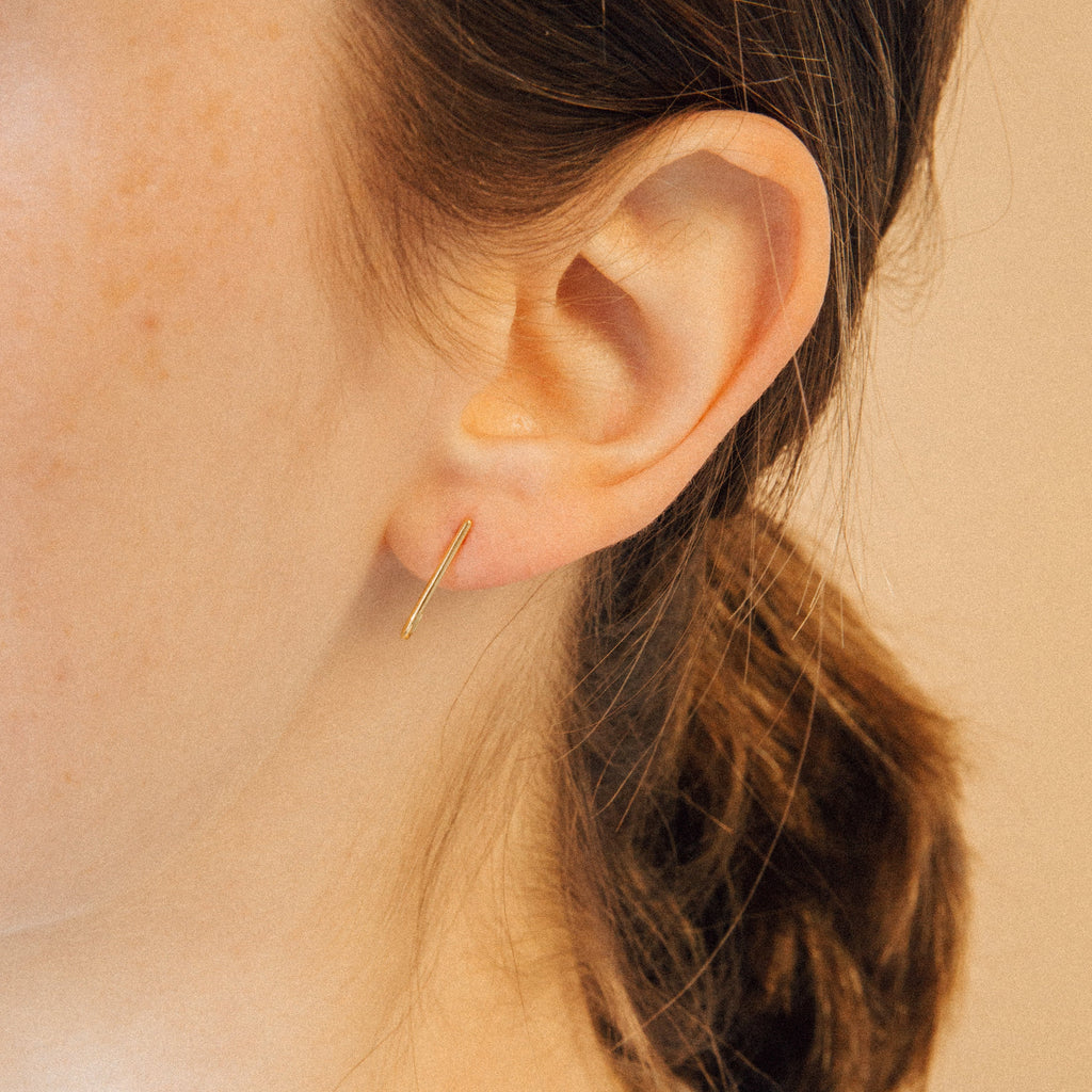 A close-up of a woman's ear adorned with Dot Ear Jackets earrings.