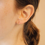 A close-up of a woman's ear adorned with Dot Ear Jackets earrings.
