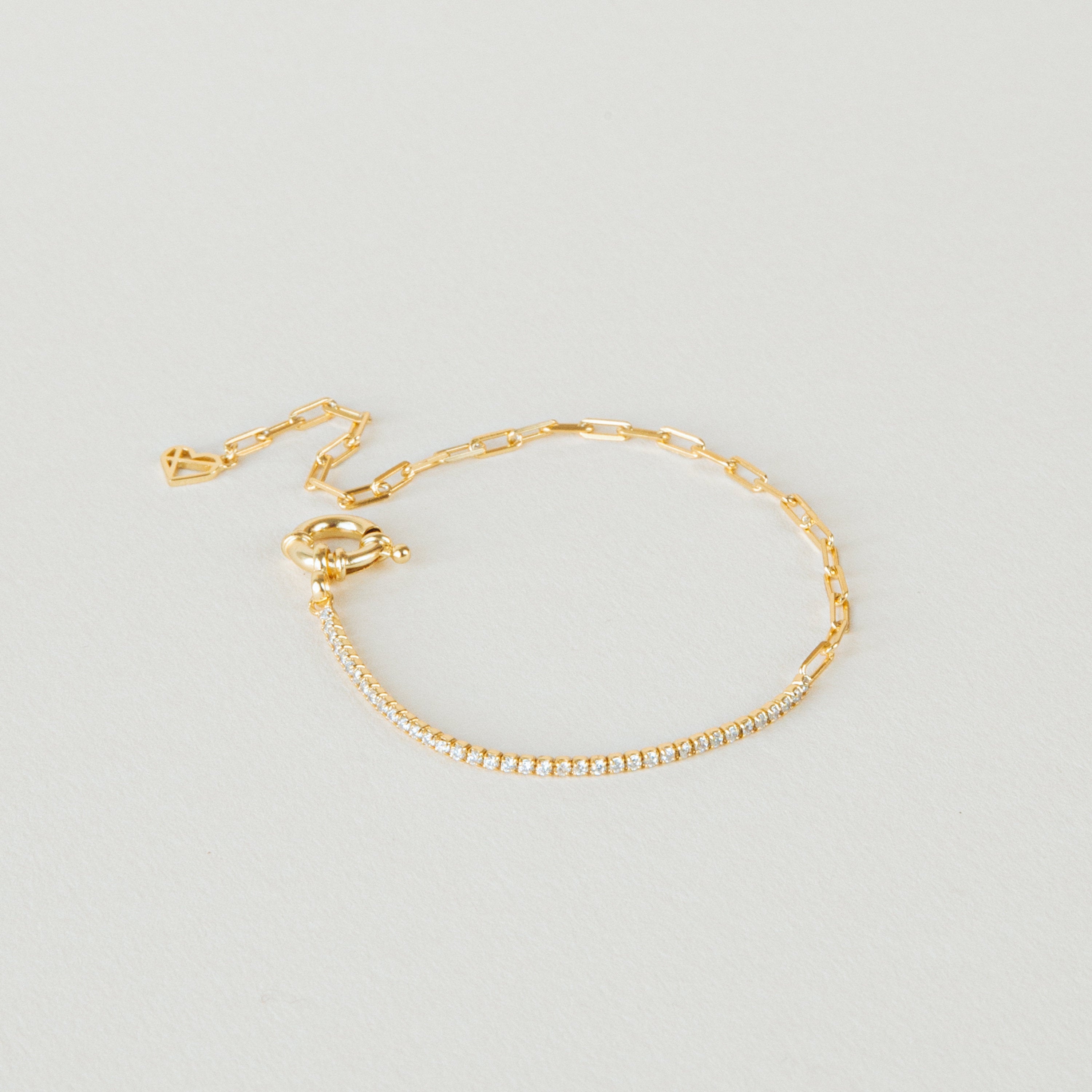 The Klara Tennis Bracelet: a minimalist gold chain with a row of small diamonds and an adjustable clasp, elegantly displayed on a light background.