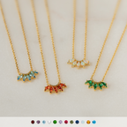 Four Marquise Birthstone Necklaces, each featuring colorful gemstone pendants, are arranged in a row on a light surface.